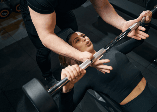 Fitness coach guiding beginner through basic strength routine in Banjara Hills