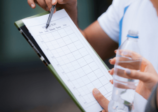 Fitness trainer helping client manage lower back pain, knee pain, and post-surgery recovery through rehabilitation training in Hyderabad